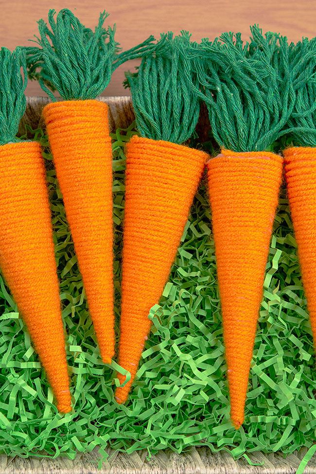 Yarn wrapped carrots in a basket with Easter grass