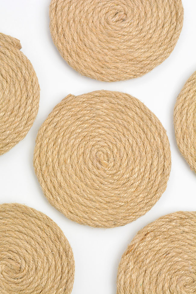 Homemade jute coasters set out on a white background