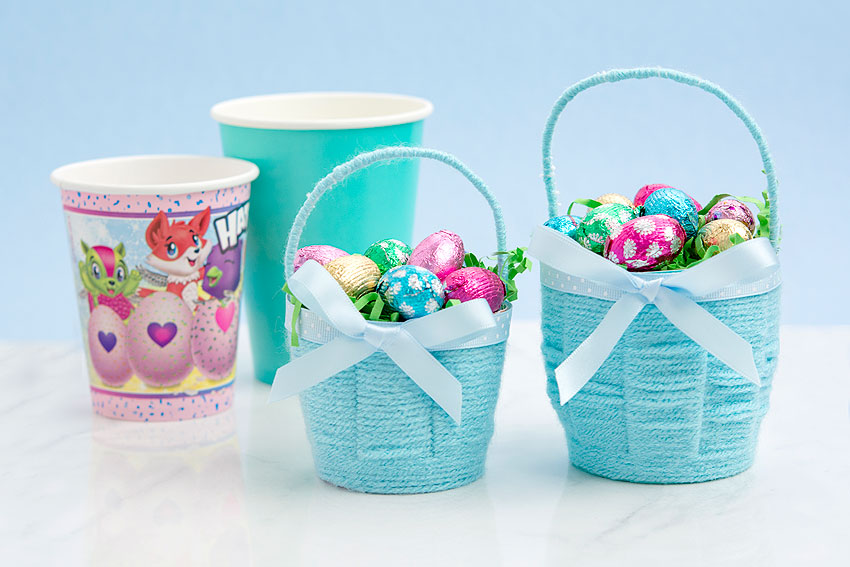 Blue DIY Easter baskets sitting beside the cups they're made from