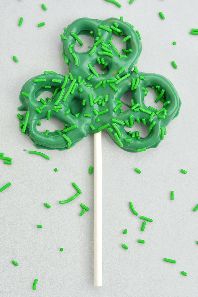 Pretzel shamrocks on a lollipop stick with sprinkles