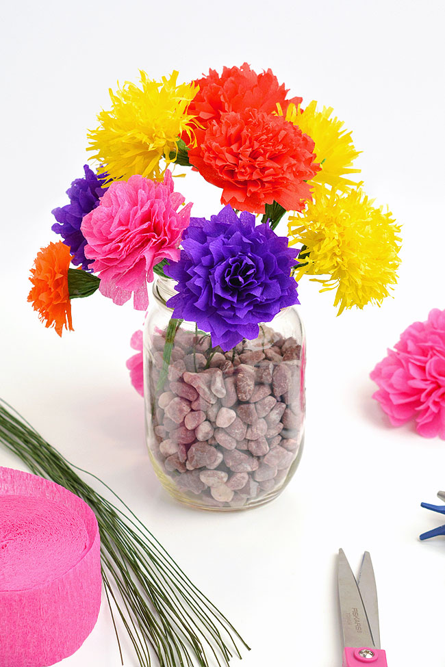 Bouquet of colourful crepe paper flowers in a mason jar vase