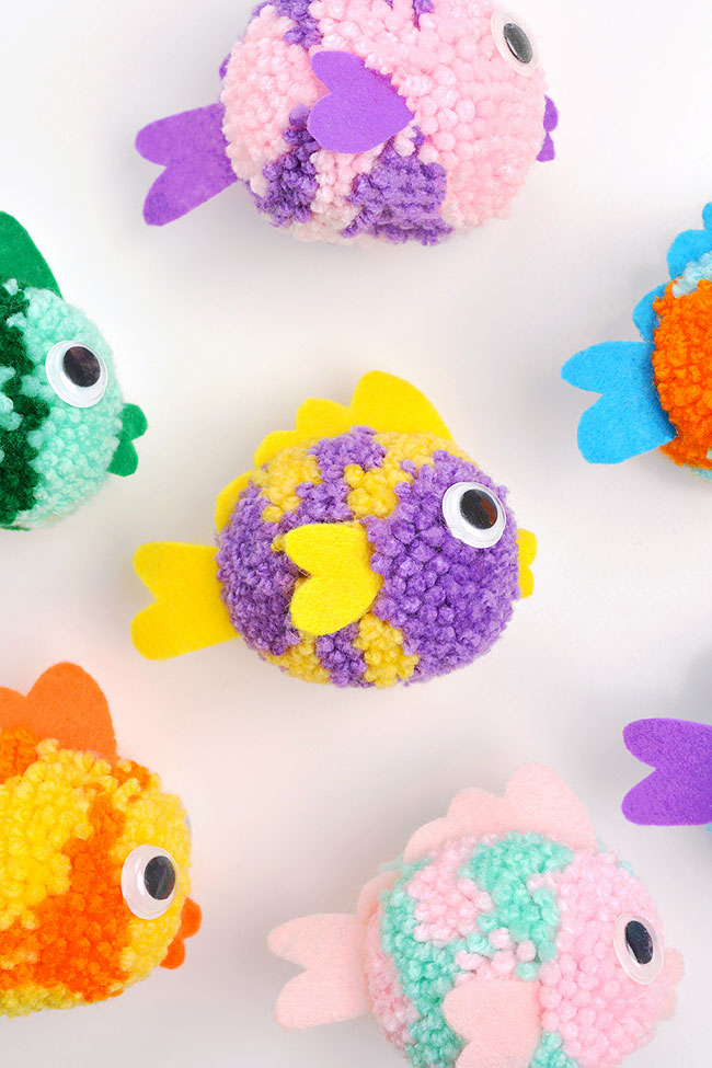 Yarn fish craft set out on a plain background