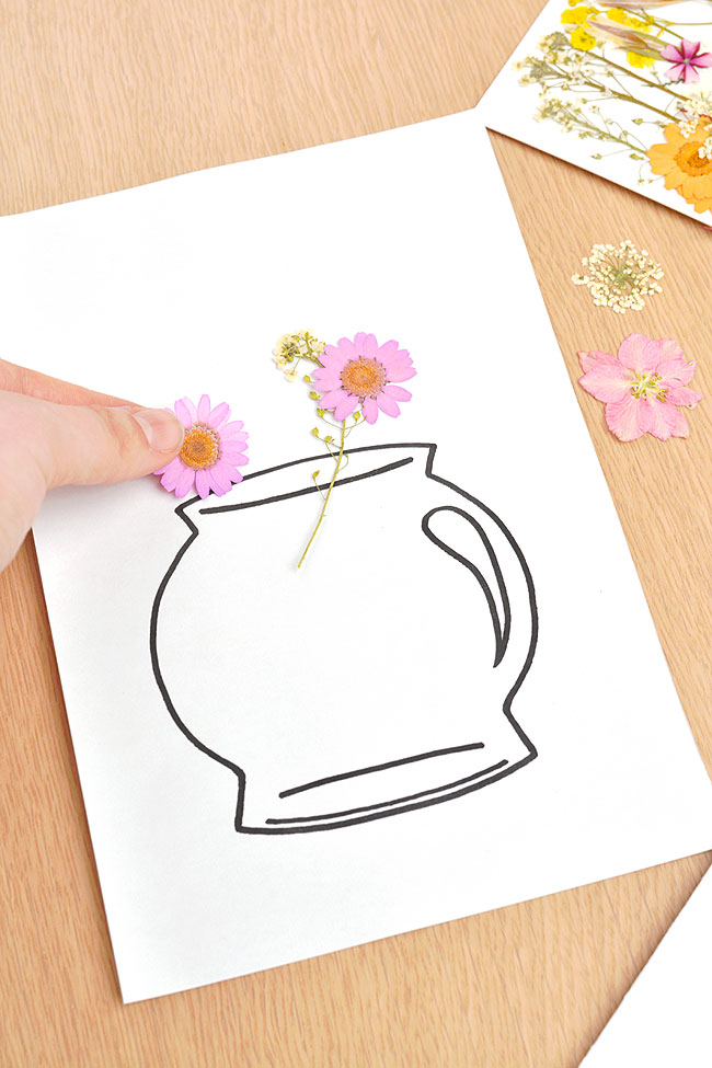 Placing pressed flowers on the front of a greeting card