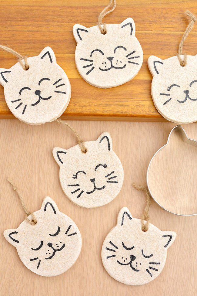Painted salt dough cat ornaments on a wooden surface