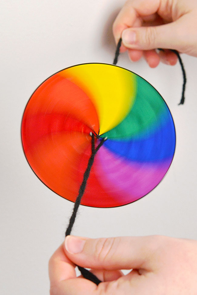 Rainbow coloured spinner toy twirling through the air