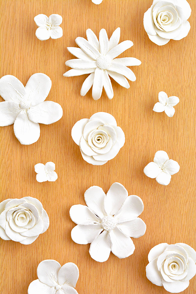 Various clay flowers on a wood table