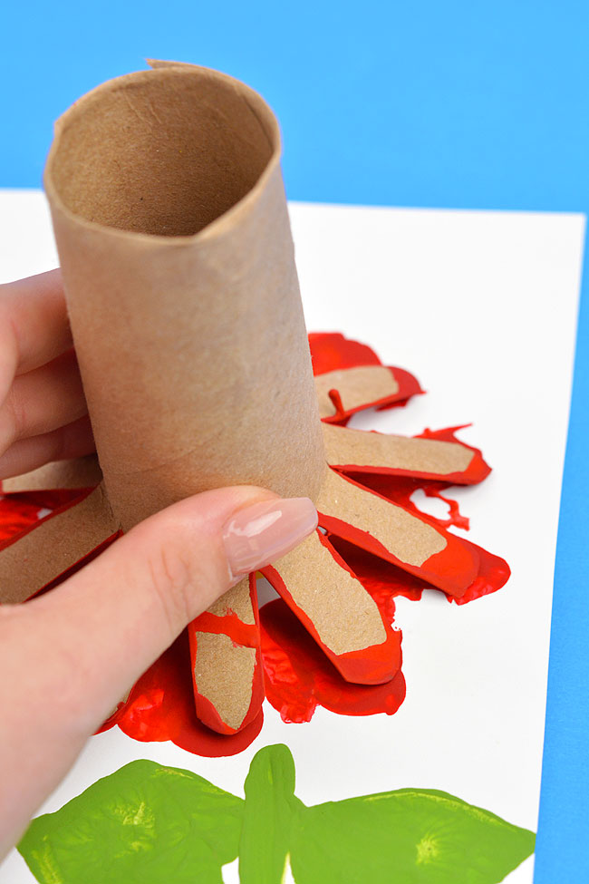 Holding a paper roll stamp to make an easy flower painting