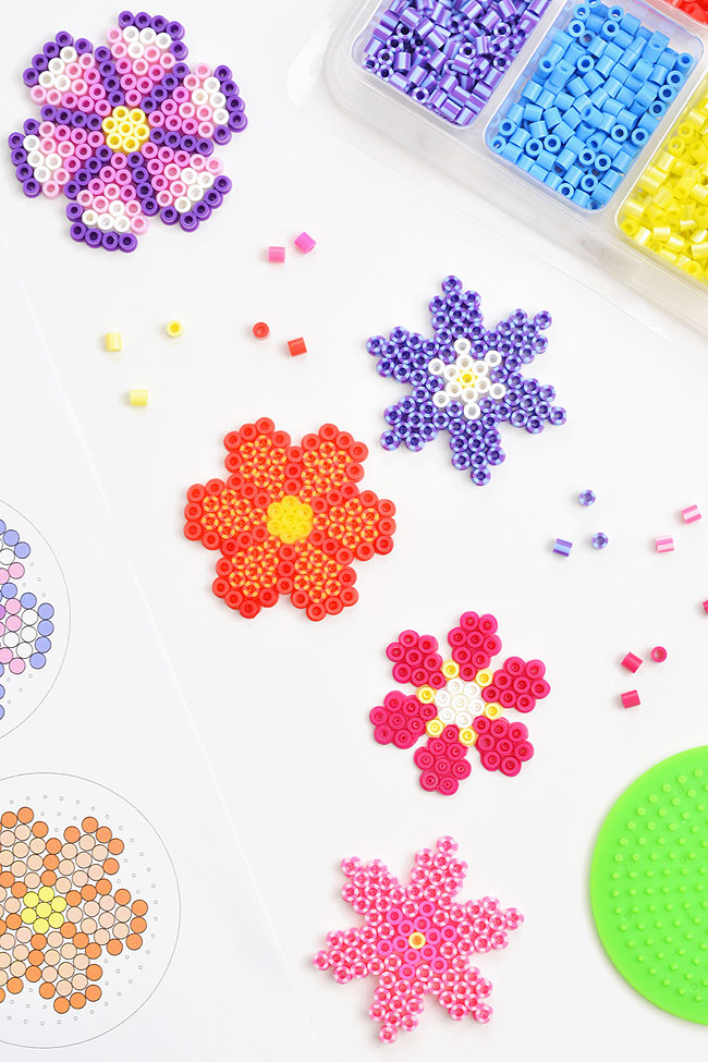 Perler bead flowers surrounded by templates and loose beads