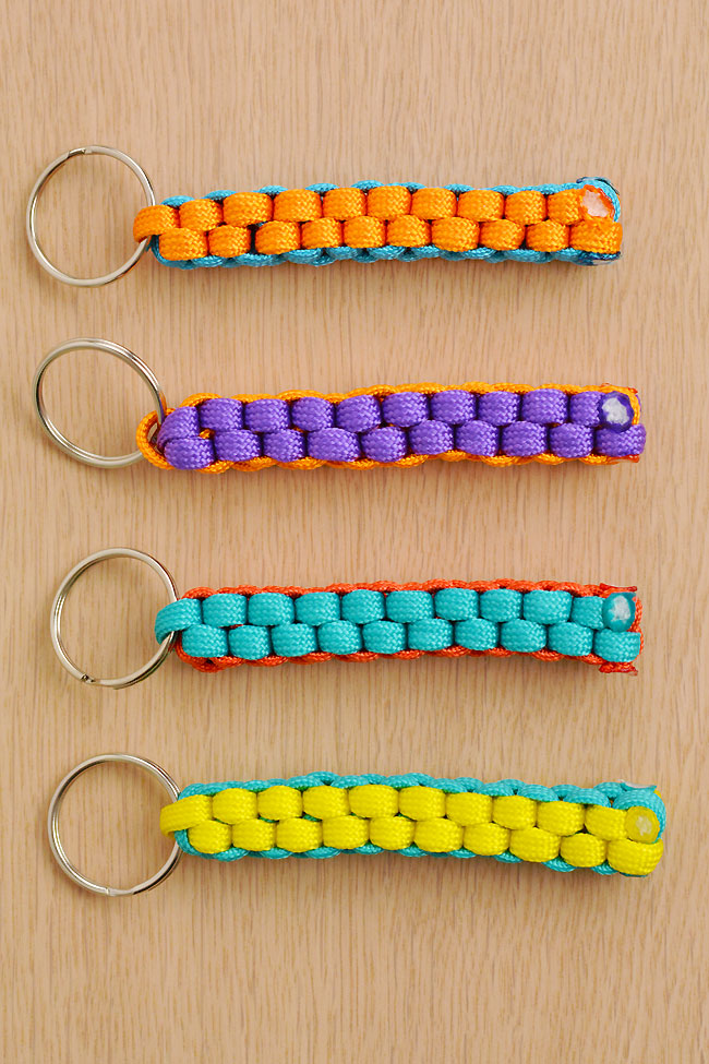 Four colourful paracord keychains on a wooden background