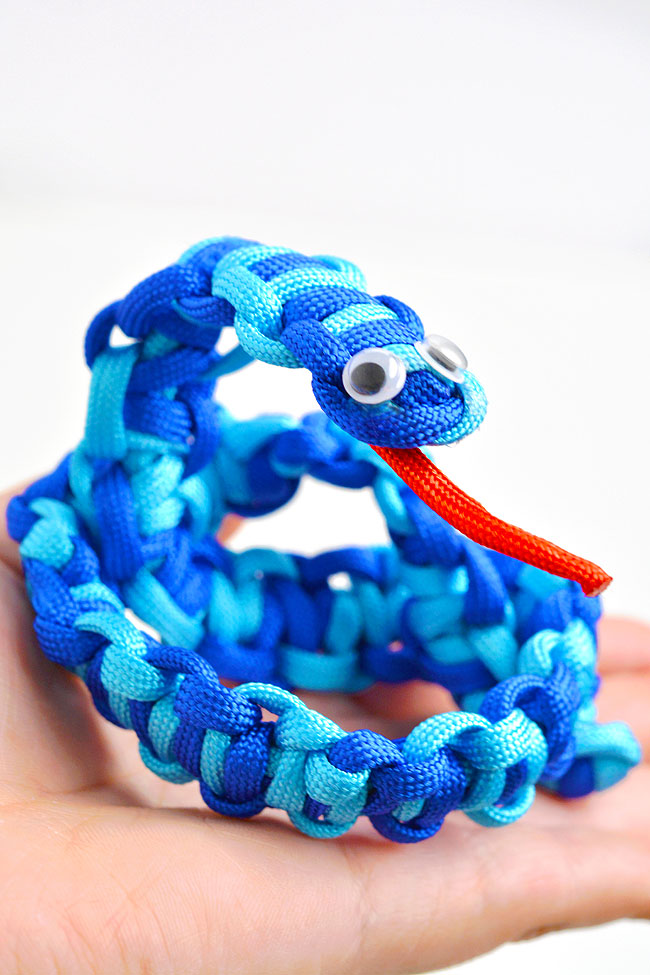 Blue paracord snake posed in a hand