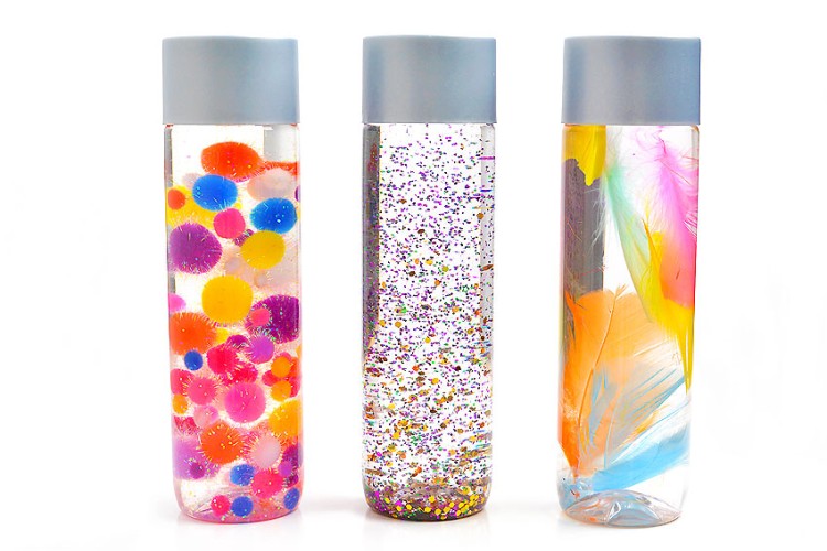 DIY sensory bottles with glitter, pom poms, and feathers