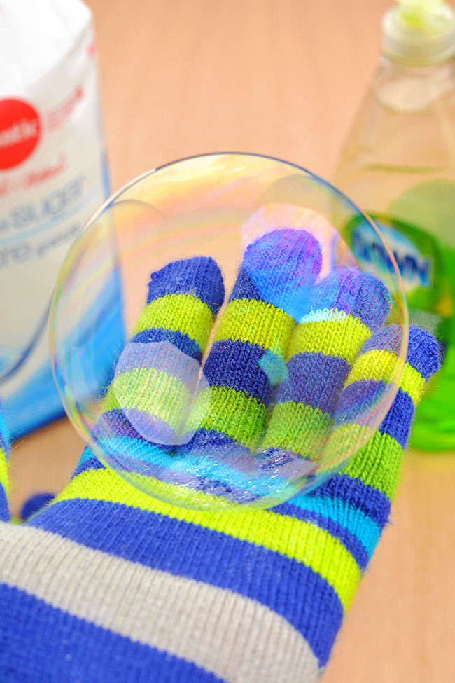 Bouncing bubble sitting on a gloved hand