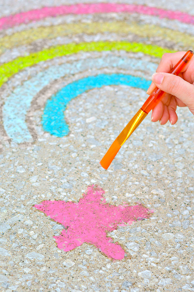 Chalk paint forming a rainbow and star on the sidewalk