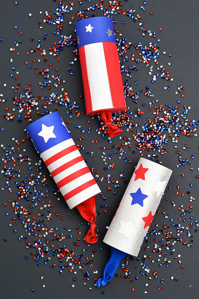 Red, white, and blue confetti poppers on a black background