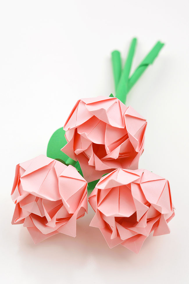 Pink paper folded roses in a group on a white background