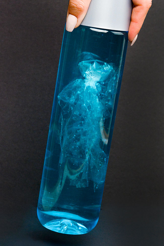 Plastic jellyfish in a bottle against a black background