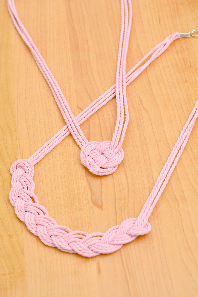 Ballet pink macrame necklaces laid out on a wooden background