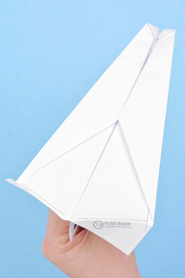 Free printable paper airplane template folded into a paper airplane