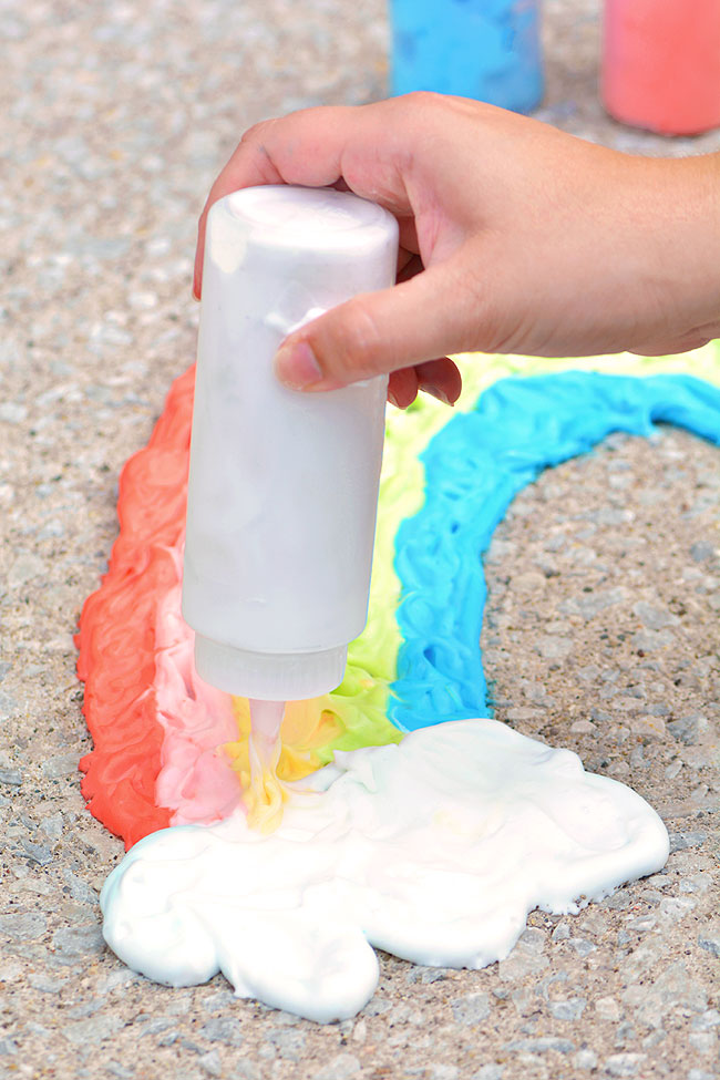 Using a squeeze bottle to paint on the pavement with puffy foam paint