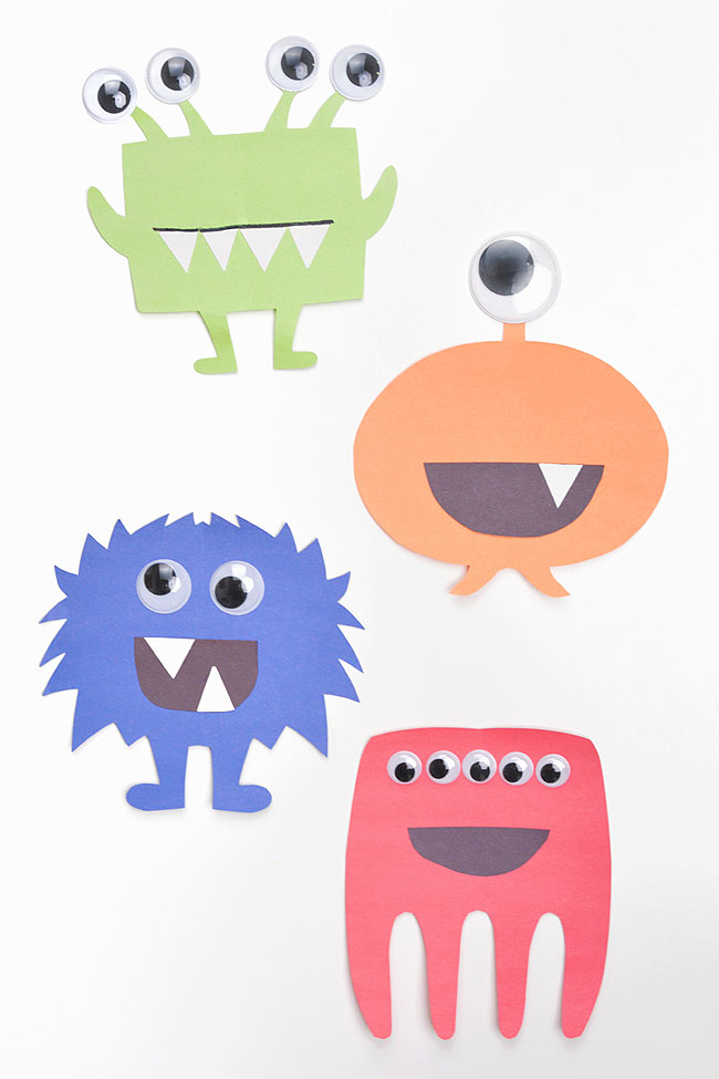 Four different paper monster designs in green, orange, blue, and red