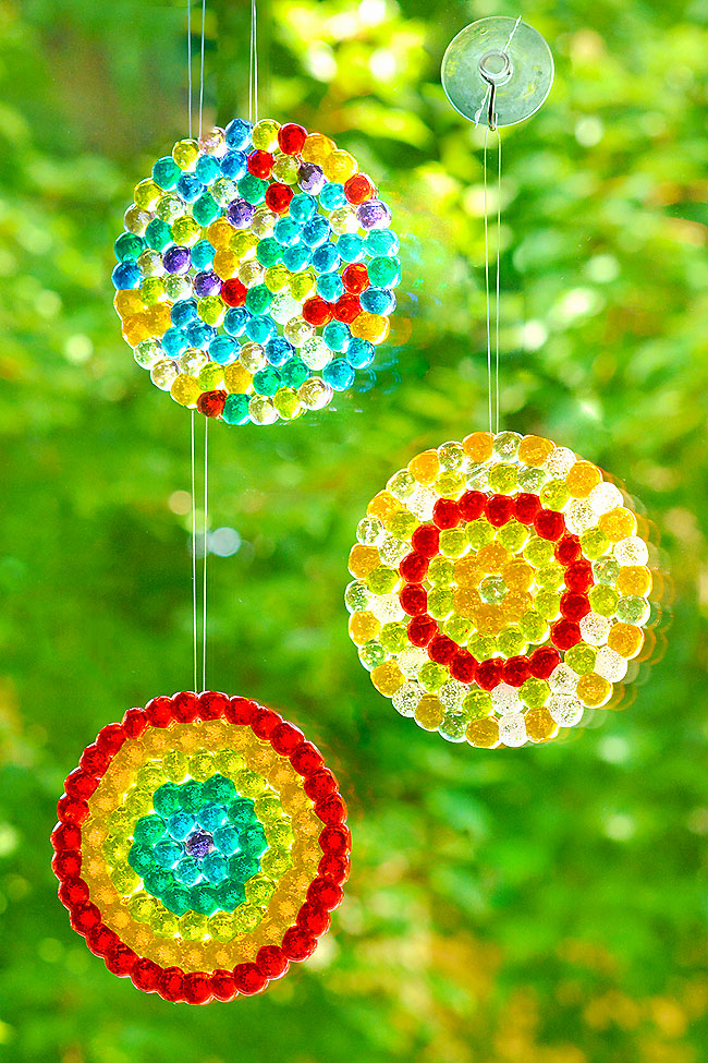 Three different designs of homemade suncatchers made with beads