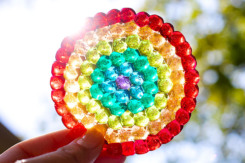 Suncatcher from melted beads with sun shining through it