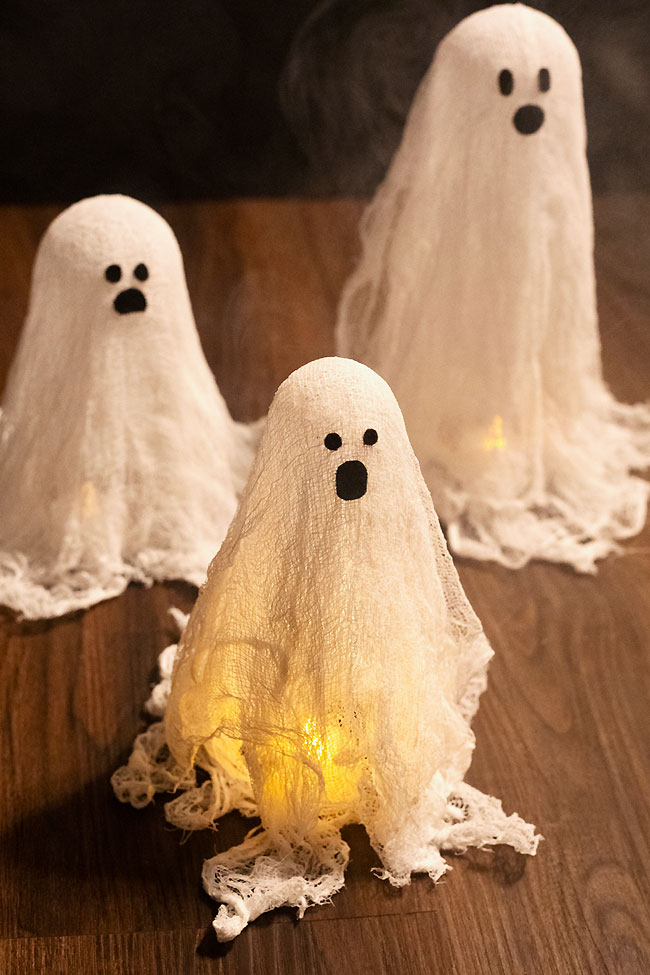 Group of cheesecloth ghosts with battery operated candles under them