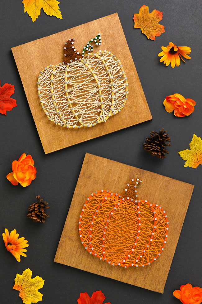 Pumpkin string art signs surrounded by fall leaves and flowers