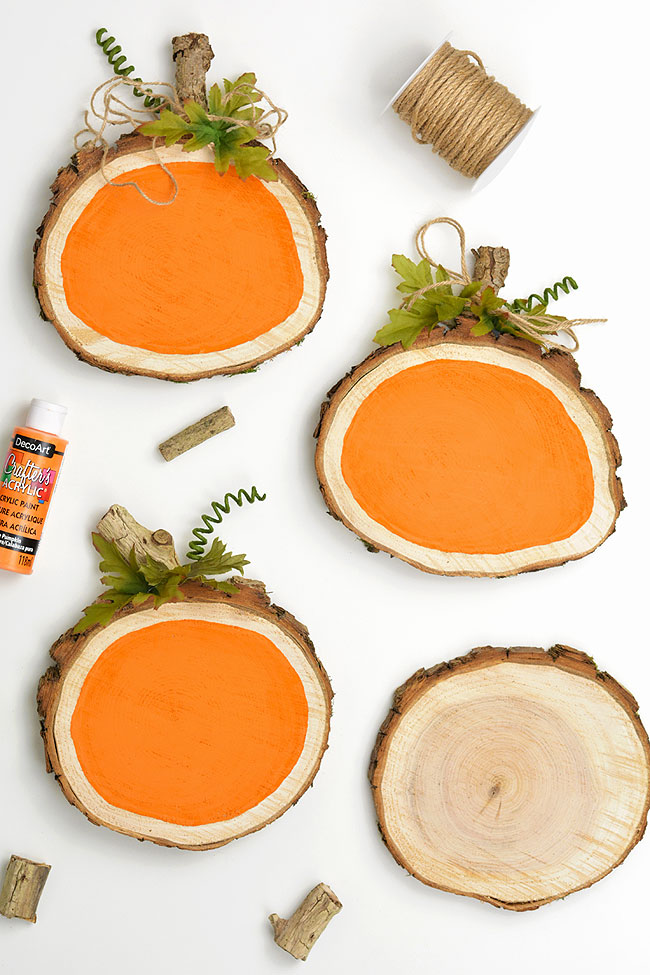 Wood slices painted orange and decorated like pumpkins