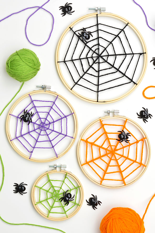 Yarn spider web made on embroidery hoops in bright Halloween colours