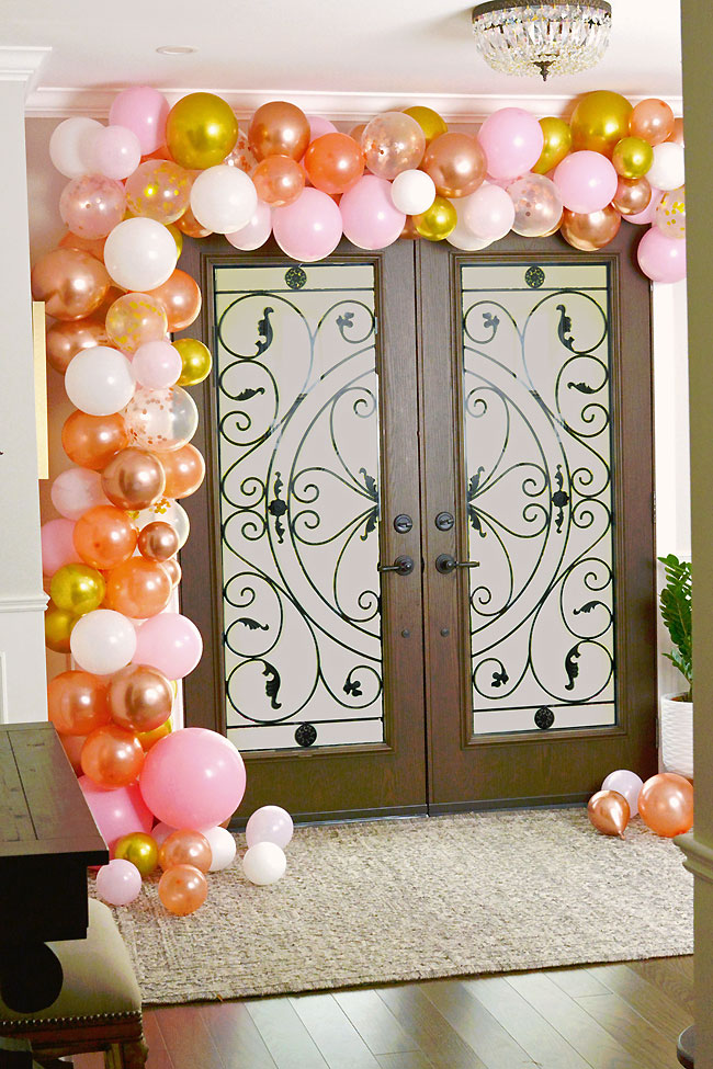 DIY balloon garland hanging over a door