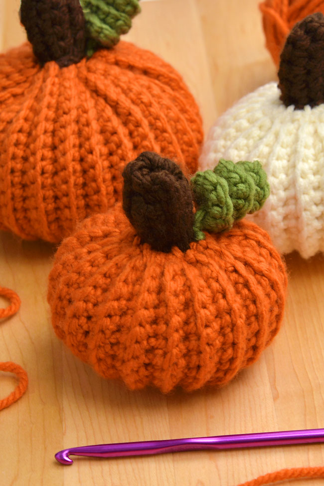 Different sizes of crochet pumpkins made with a free pattern