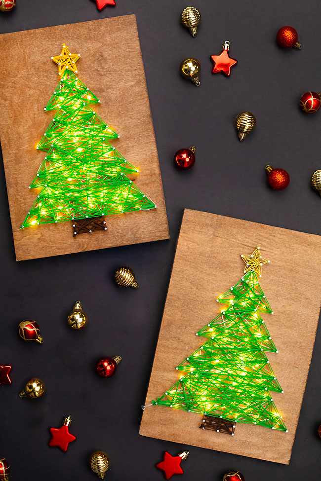 Christmas tree string art signs on a black background with Christmas ornaments