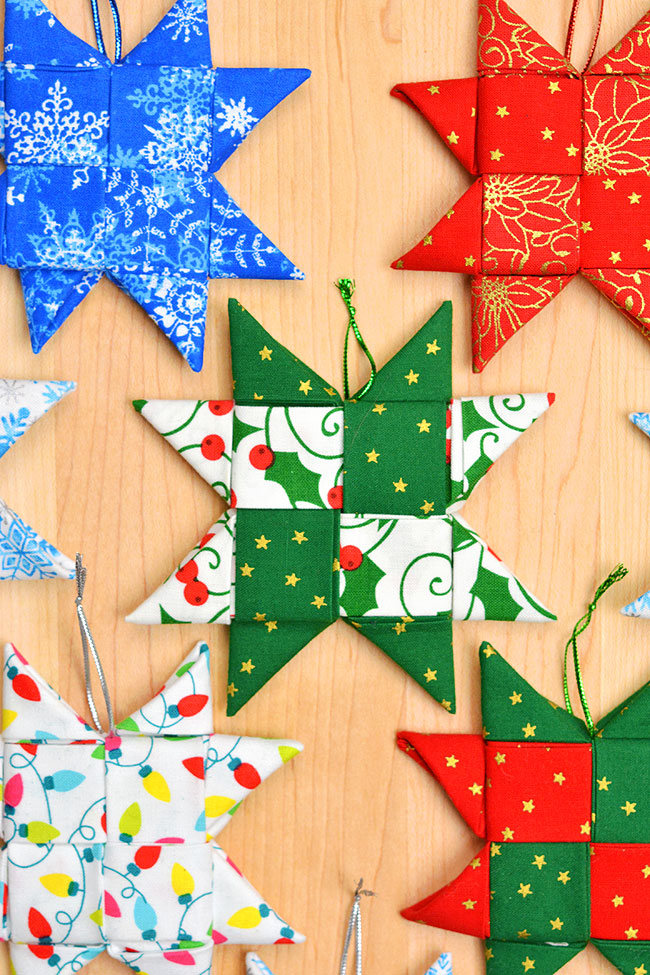 Homemade fabric star ornaments sitting on a wooden background