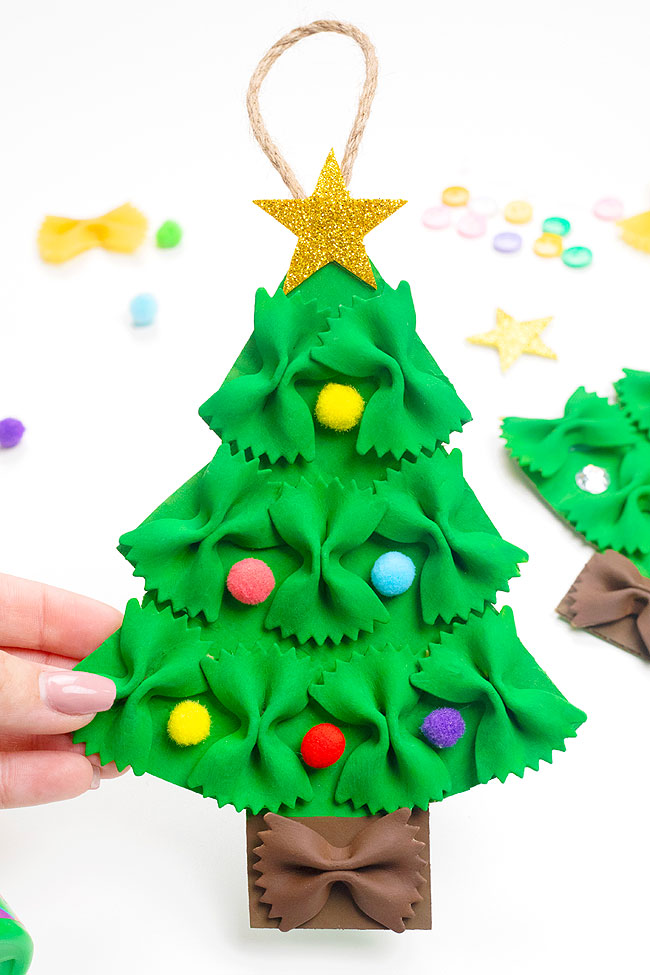 Christmas tree shaped pasta ornament with pom poms and a glittery foam star