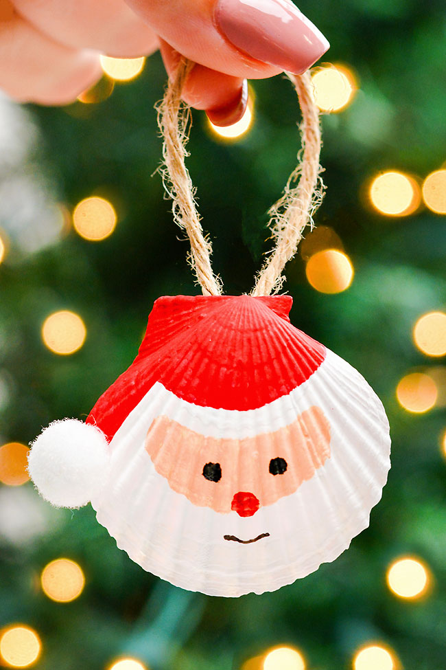DIY seashell Santa ornament in front of the Christmas tree