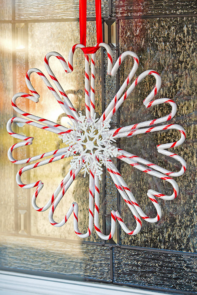 Homemade candy cane wreath hanging on a glass door