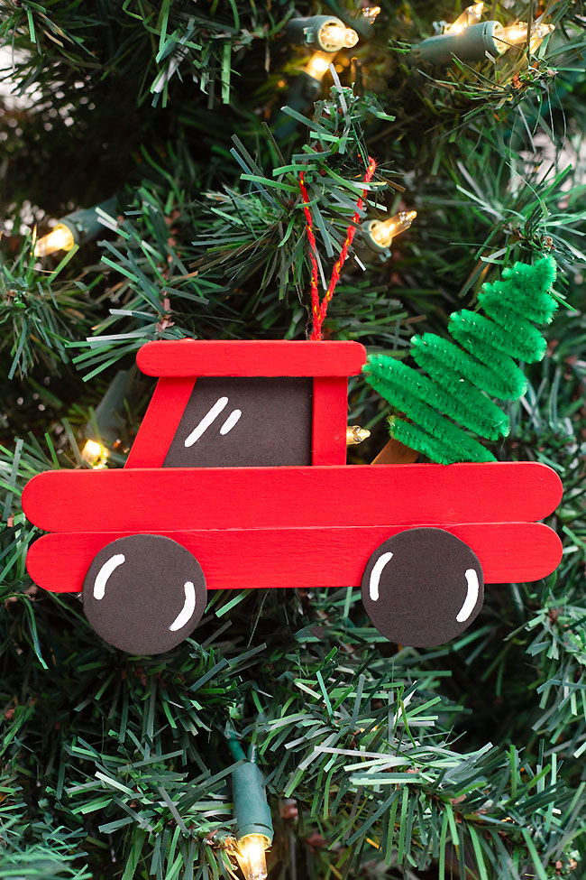 Red truck popsicle stick ornament hanging on the Christmas tree