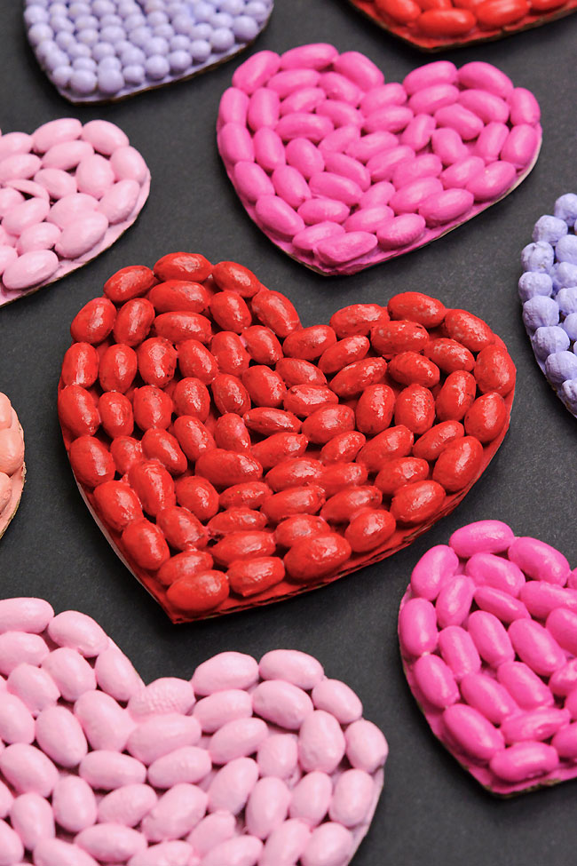 Colourful bean art hearts on a black background