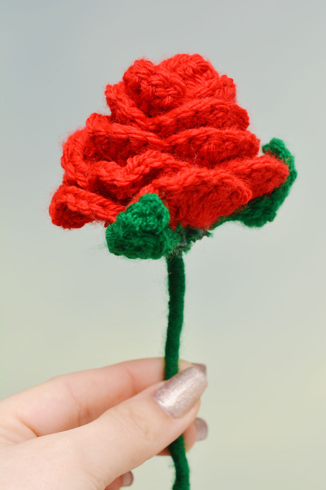 Holding a crochet rose made with a free printable pattern