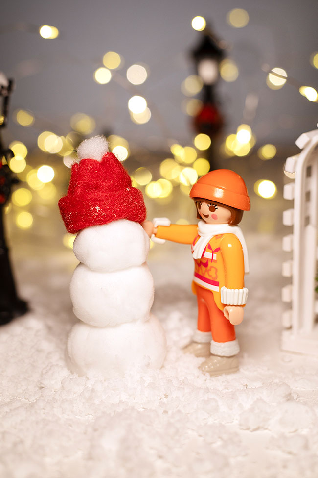 Plastic toy "building" a snowman from DIY fake snow