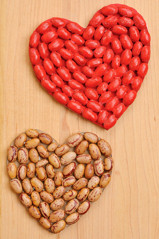 Bean art on a heart outline, one painted red and one before it was painted