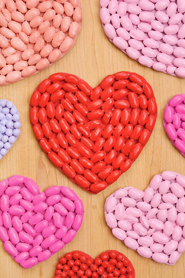 Beans arranged onto heart shaped DIY Valentines and painted red and pink