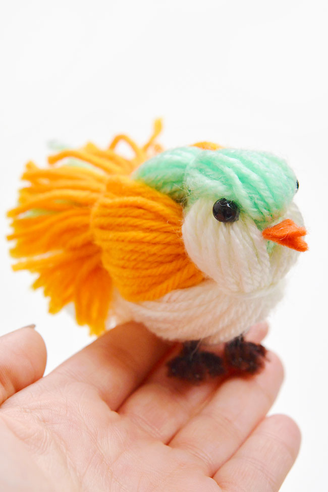 Holding a DIY yarn bird