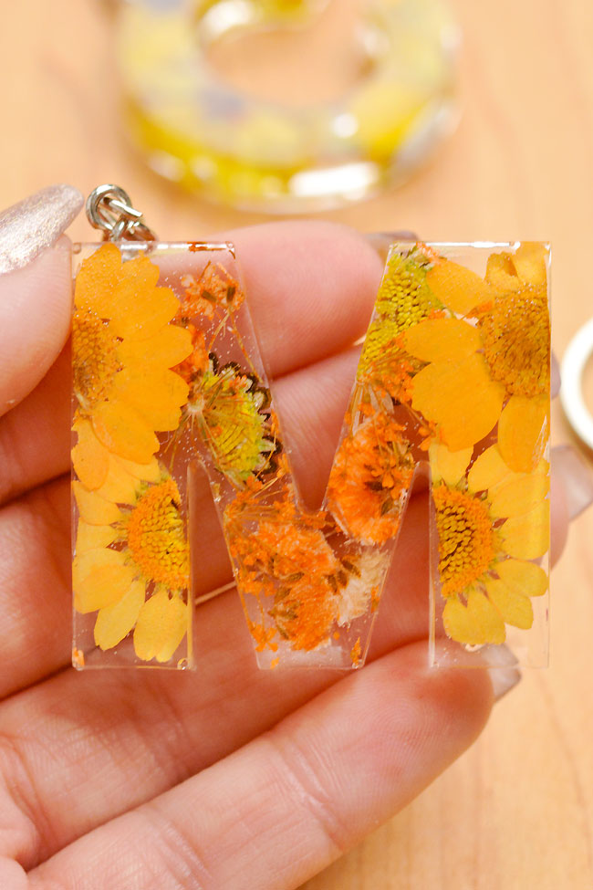 Holding a yellow resin letter keychain