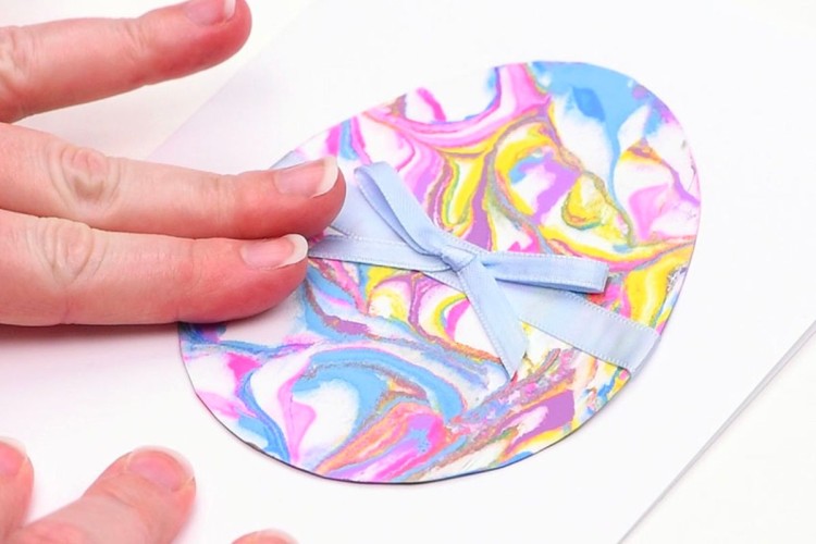 Acrylic paint, cardstock, and ribbon used to make make marbled paper Easter eggs