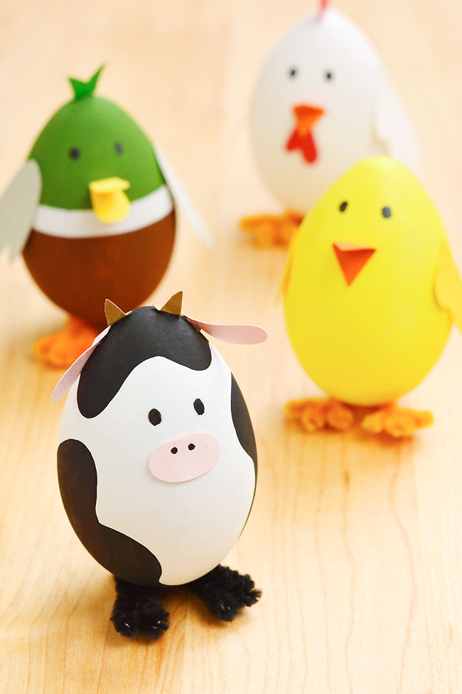 Group of Easter egg farm animals standing on a wooden background