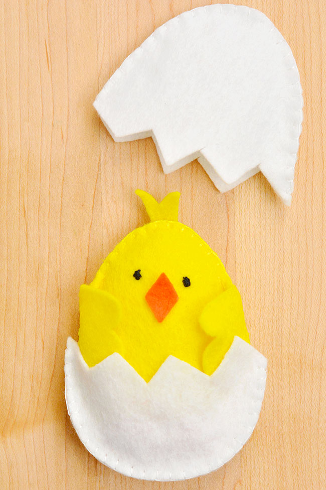 Yellow felt chick sitting in its eggshell home