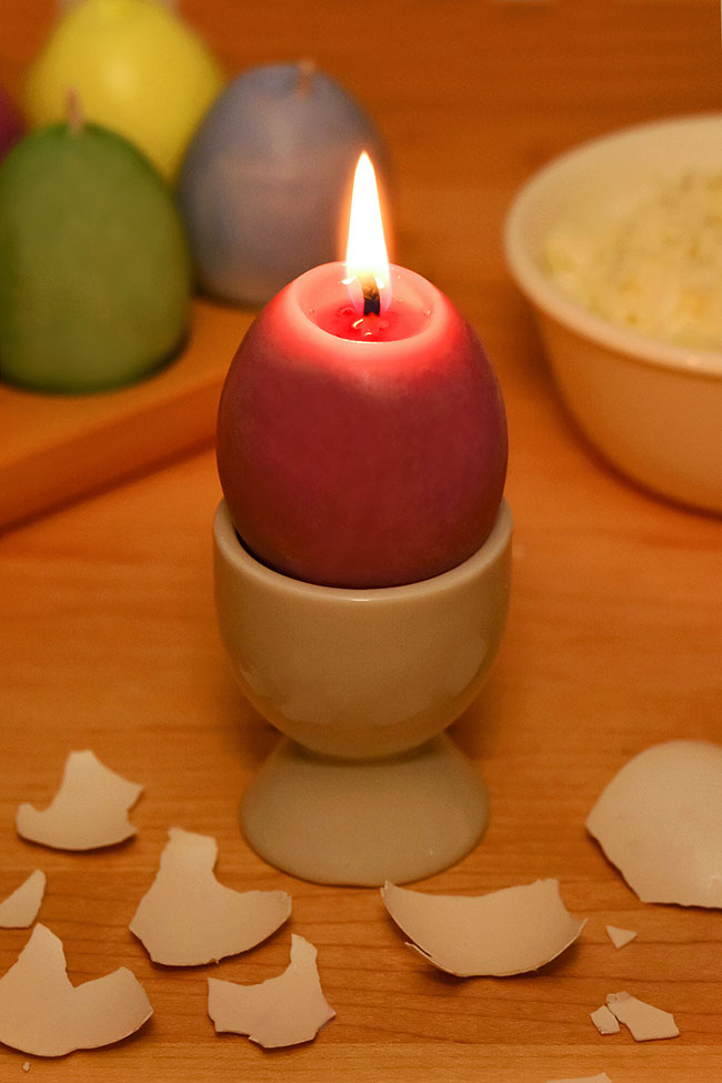 Burning an egg shaped candle in an egg cup