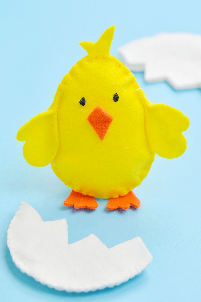 Super cute baby Easter chick standing with his shell around him